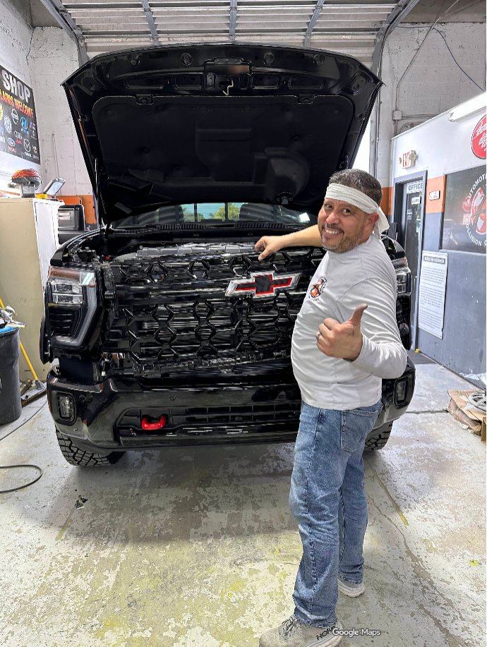 Dentro de Automotive World Collision Center — el equipo trabajando en el taller de Miami